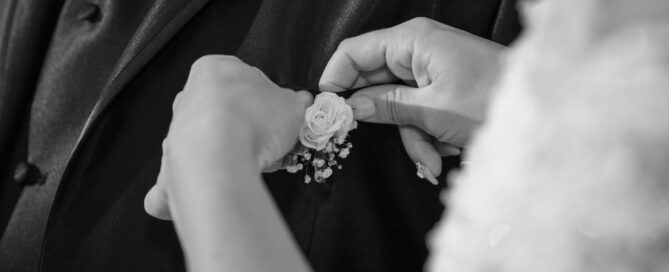 Wedding Photography_The bride arranges the flower in her father's boutonniere_detail
